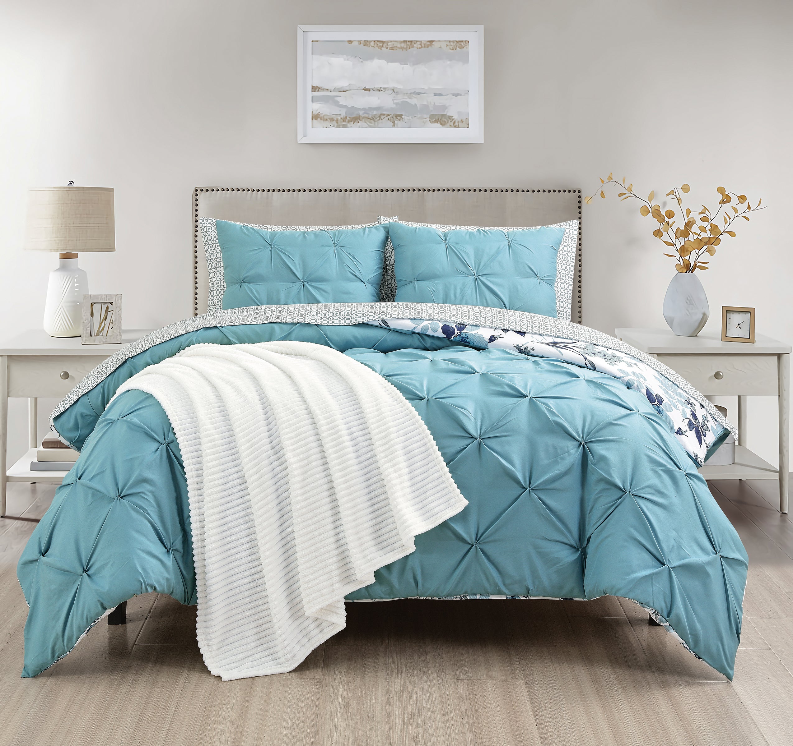 Teal comforter set on a bed in a bedroom with side tables and decor.
