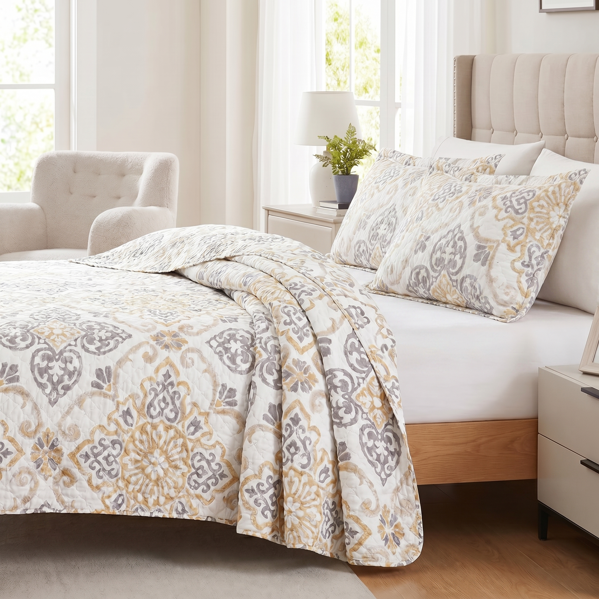 Bedroom with a bed featuring a patterned comforter and pillows, surrounded by furniture and decor.