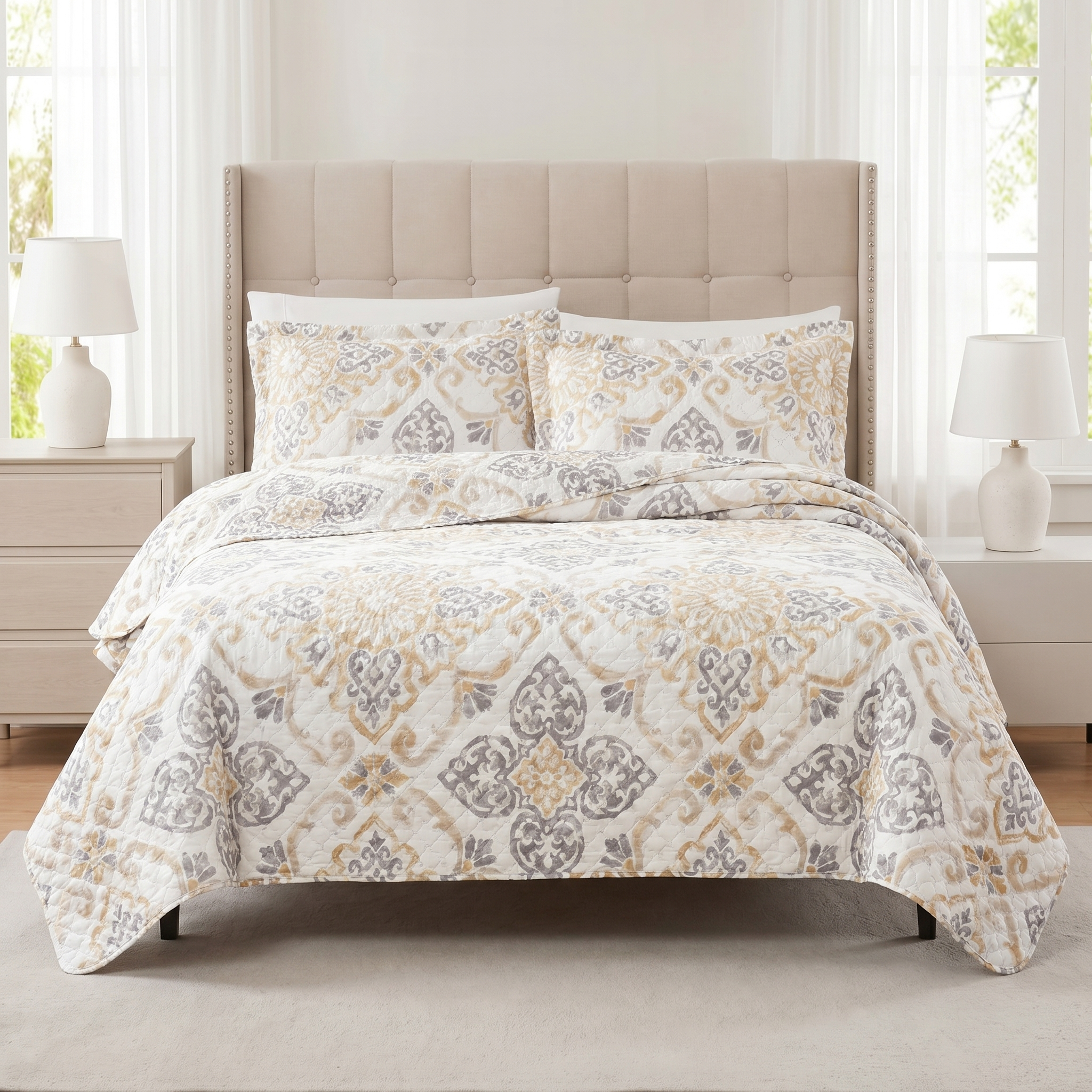 Patterned quilt set on a bed with matching pillows in a bedroom setting.