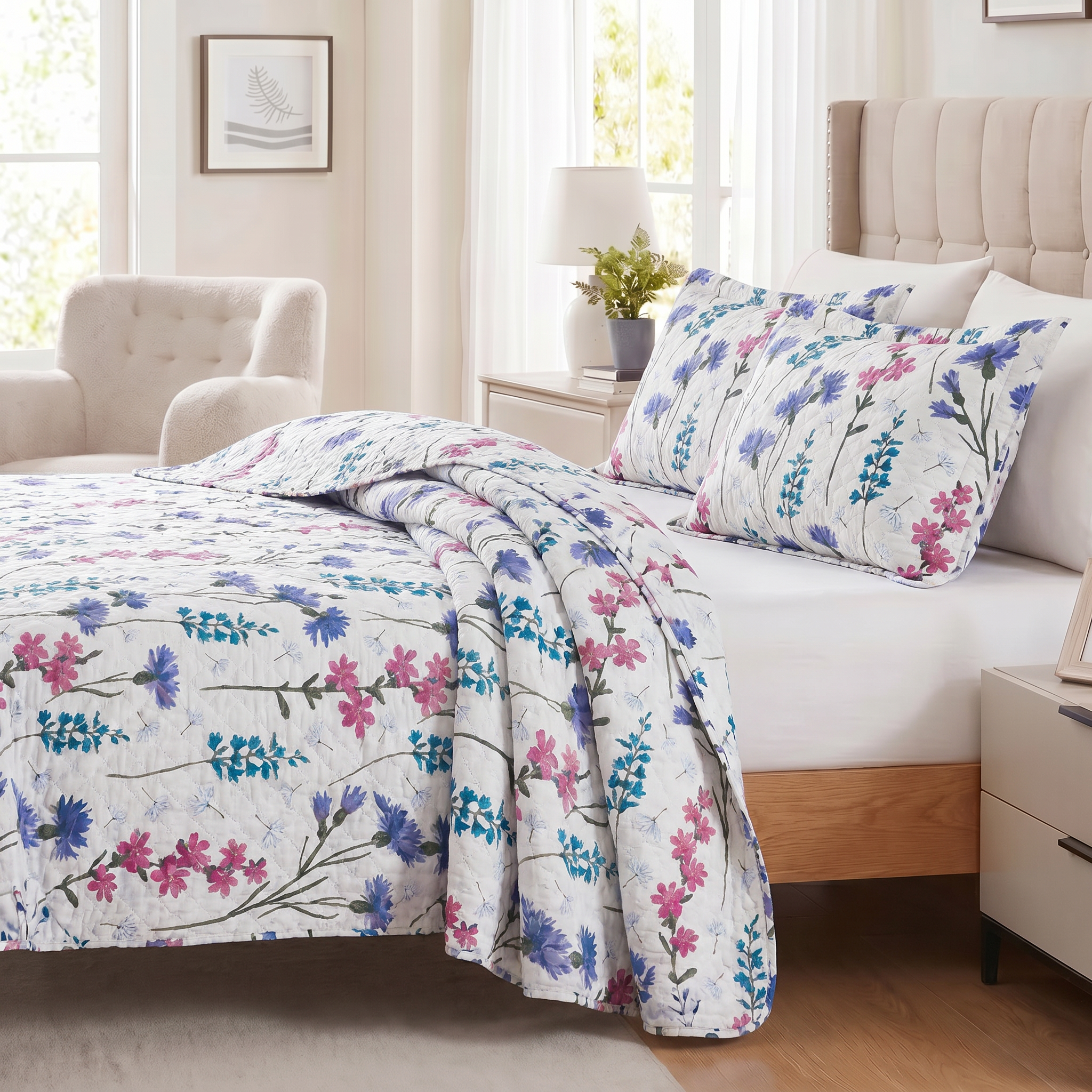 Floral bedding set on a bed in a bedroom with a lamp and chair.