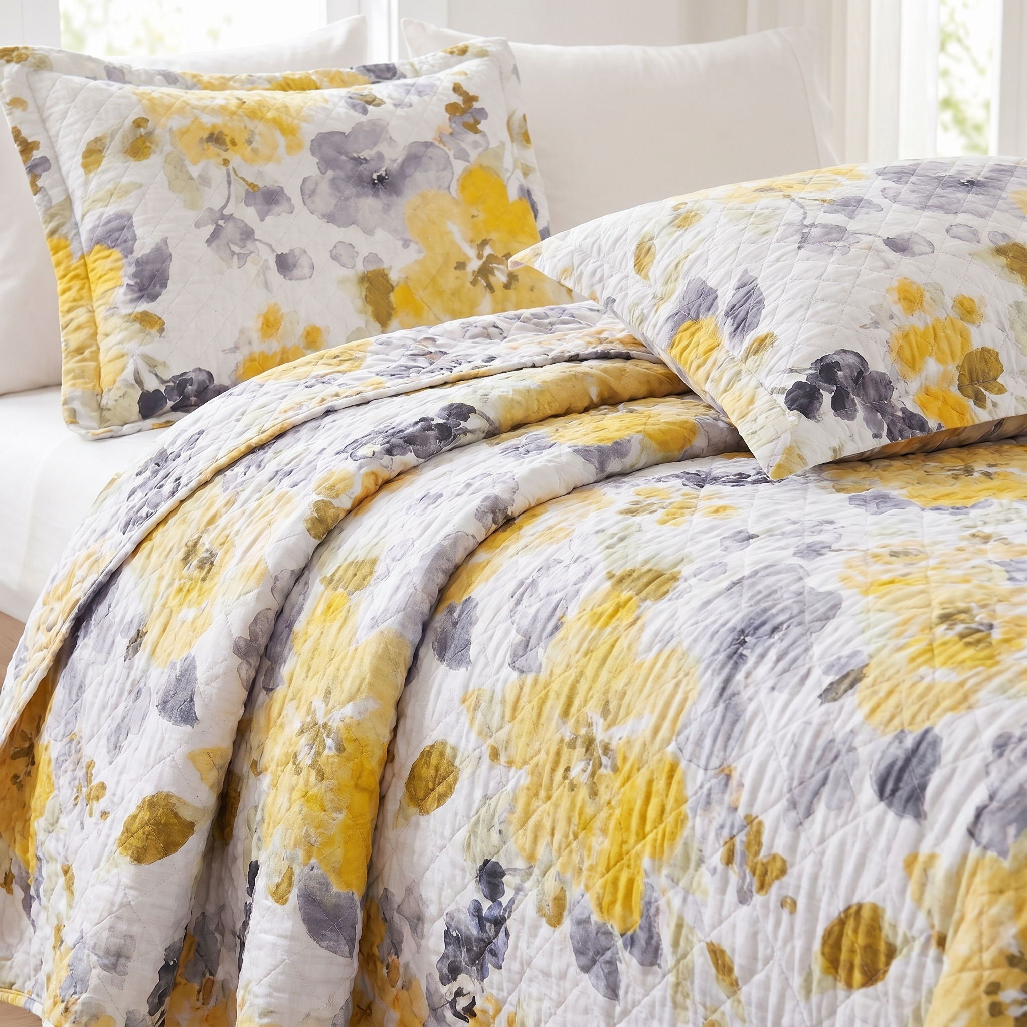 Floral patterned bedding set with yellow and gray flowers on a bed.