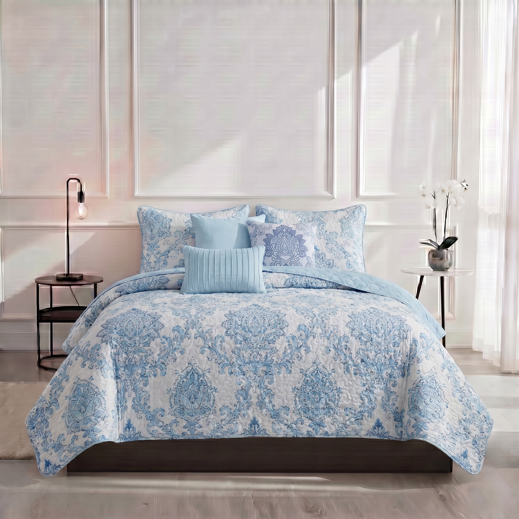 Blue and white patterned comforter set on a bed in a bedroom.