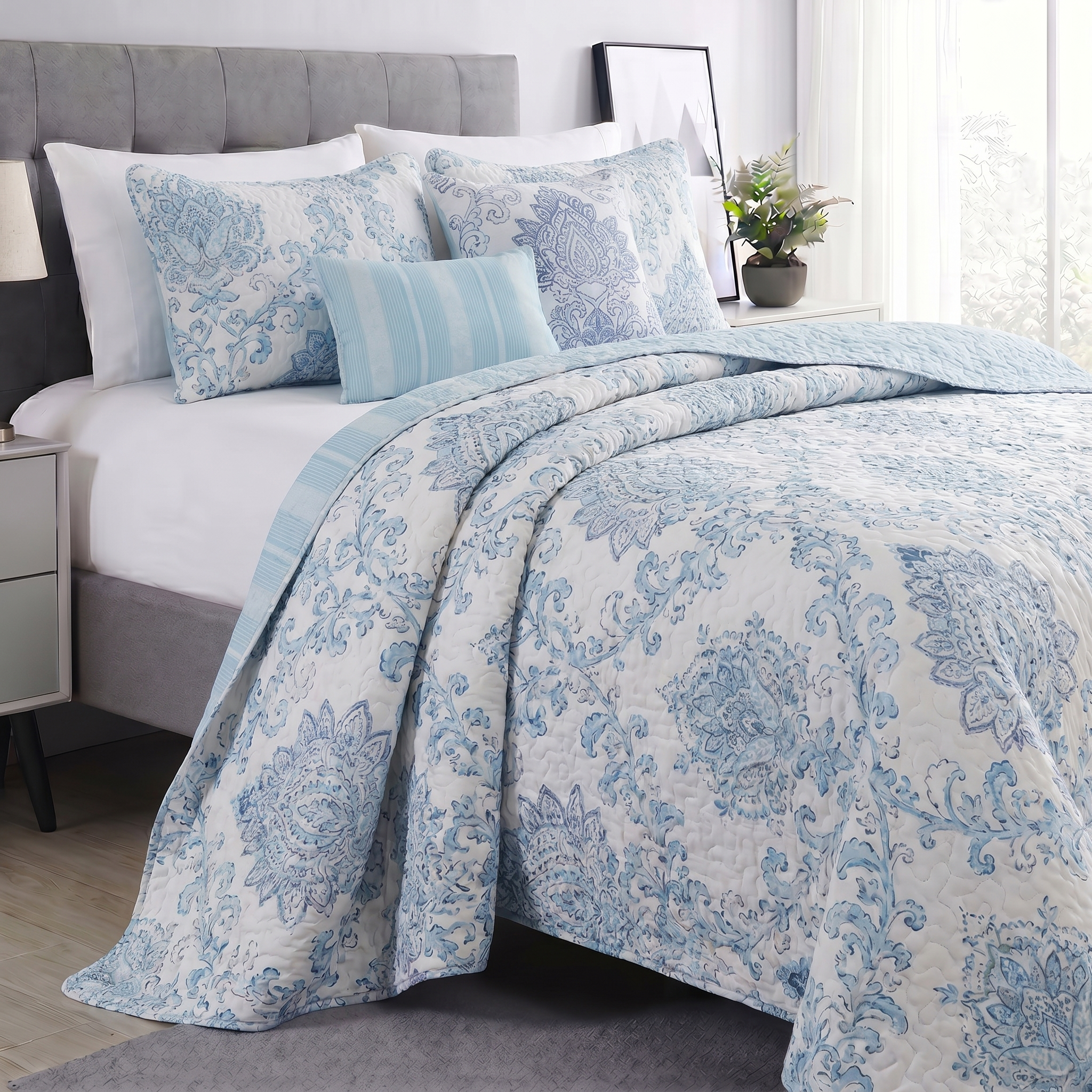 Bed with blue floral patterned bedding in a bedroom setting