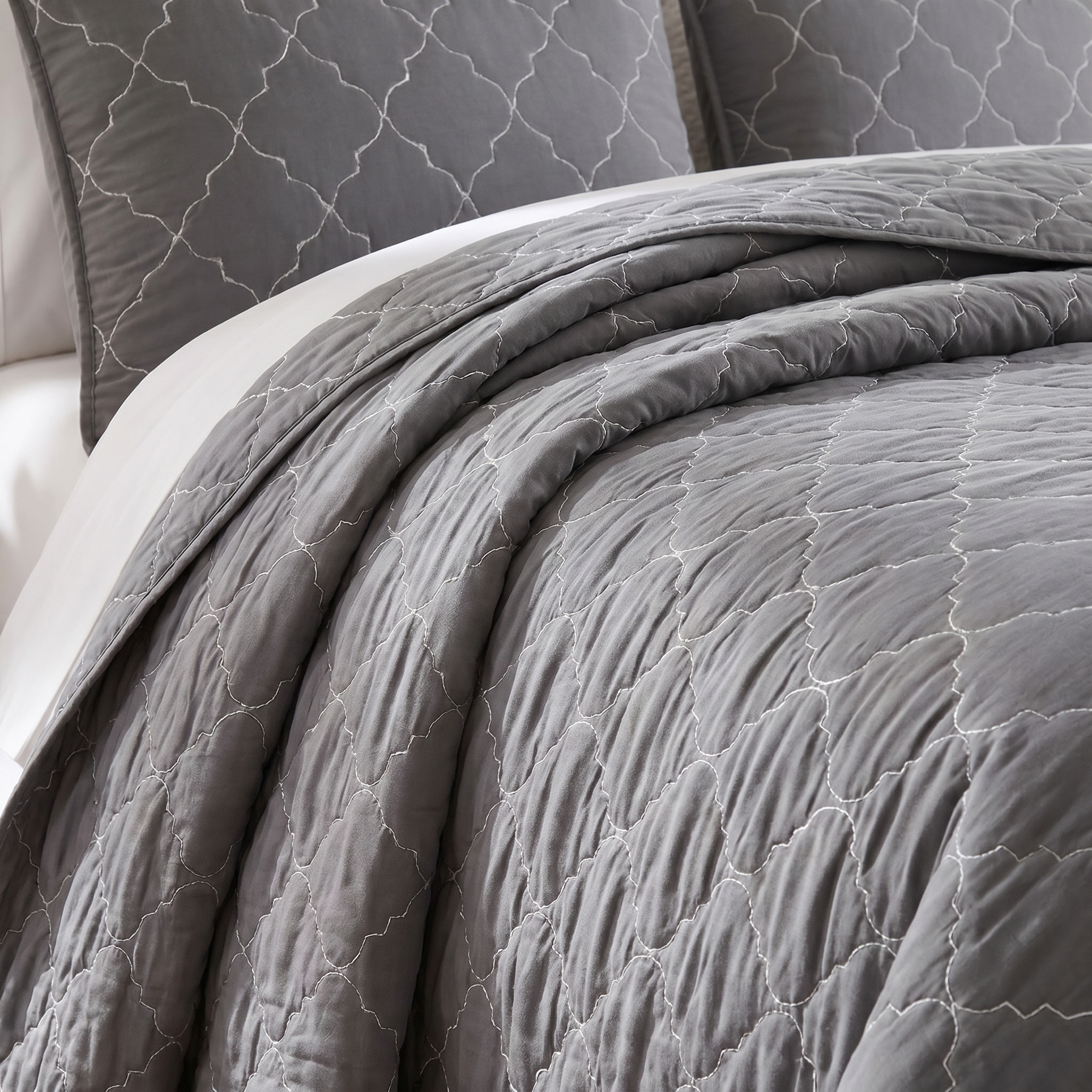 Gray textured comforter on a bed with matching pillows