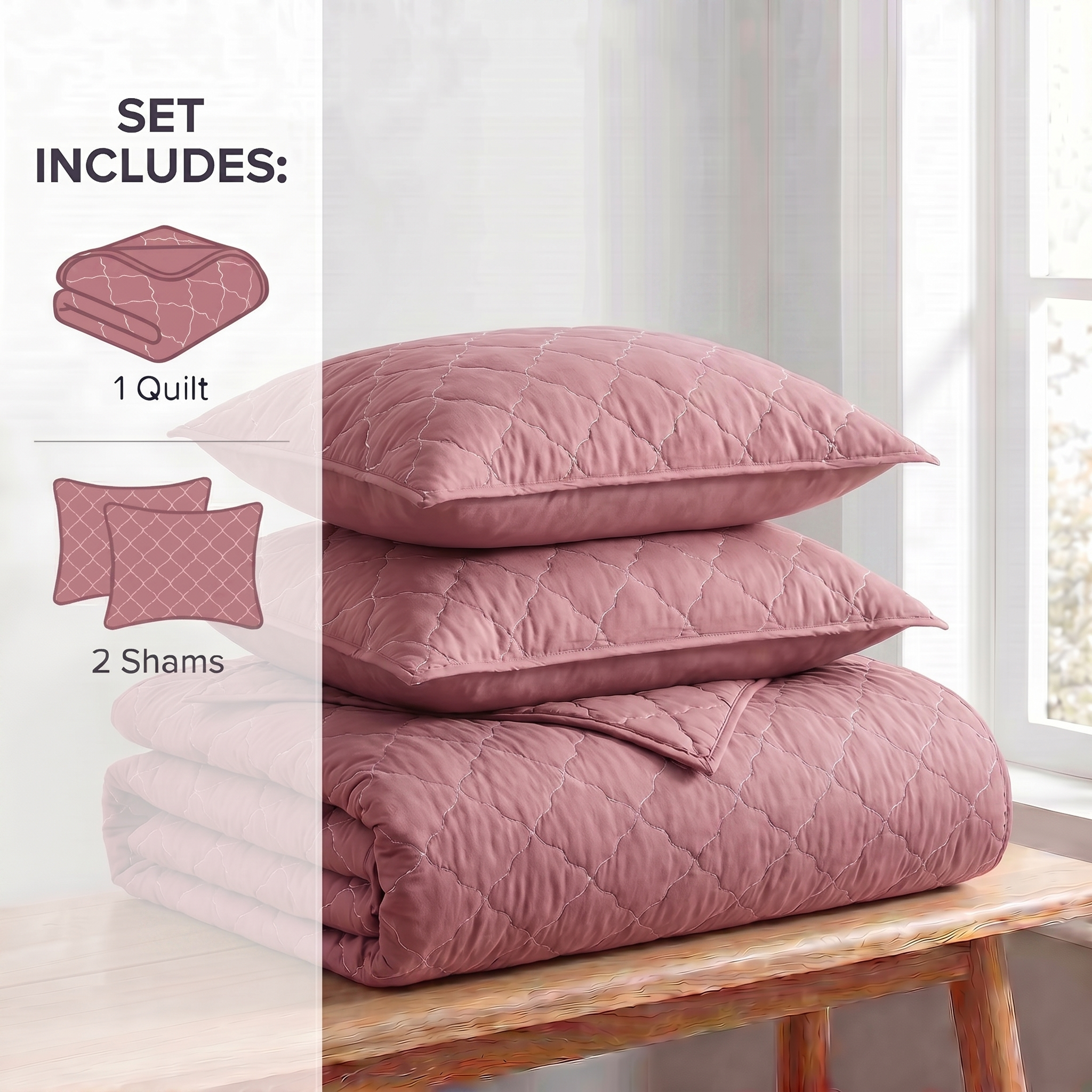 Pink quilt set with two shams on a wooden bench in a bright room.