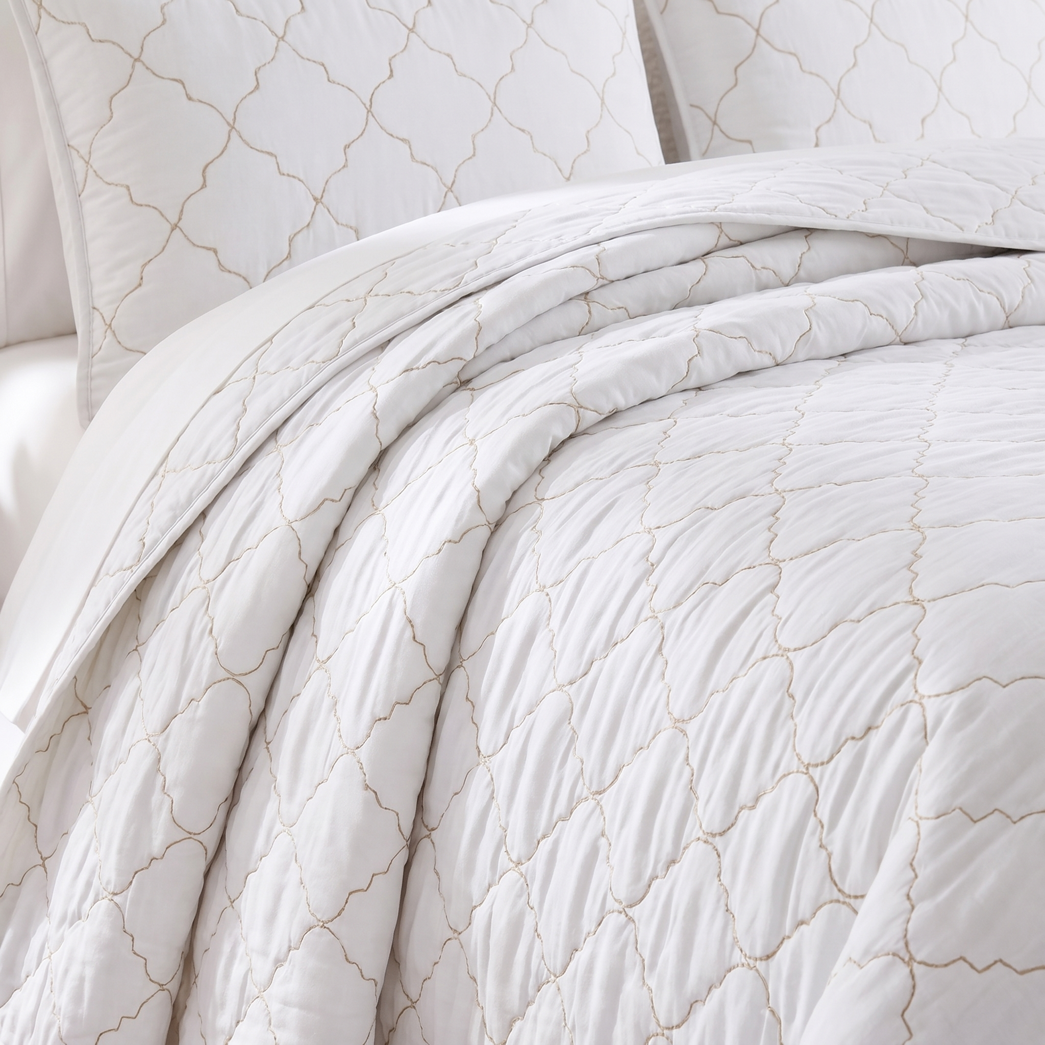 White quilt with subtle pattern on a bed