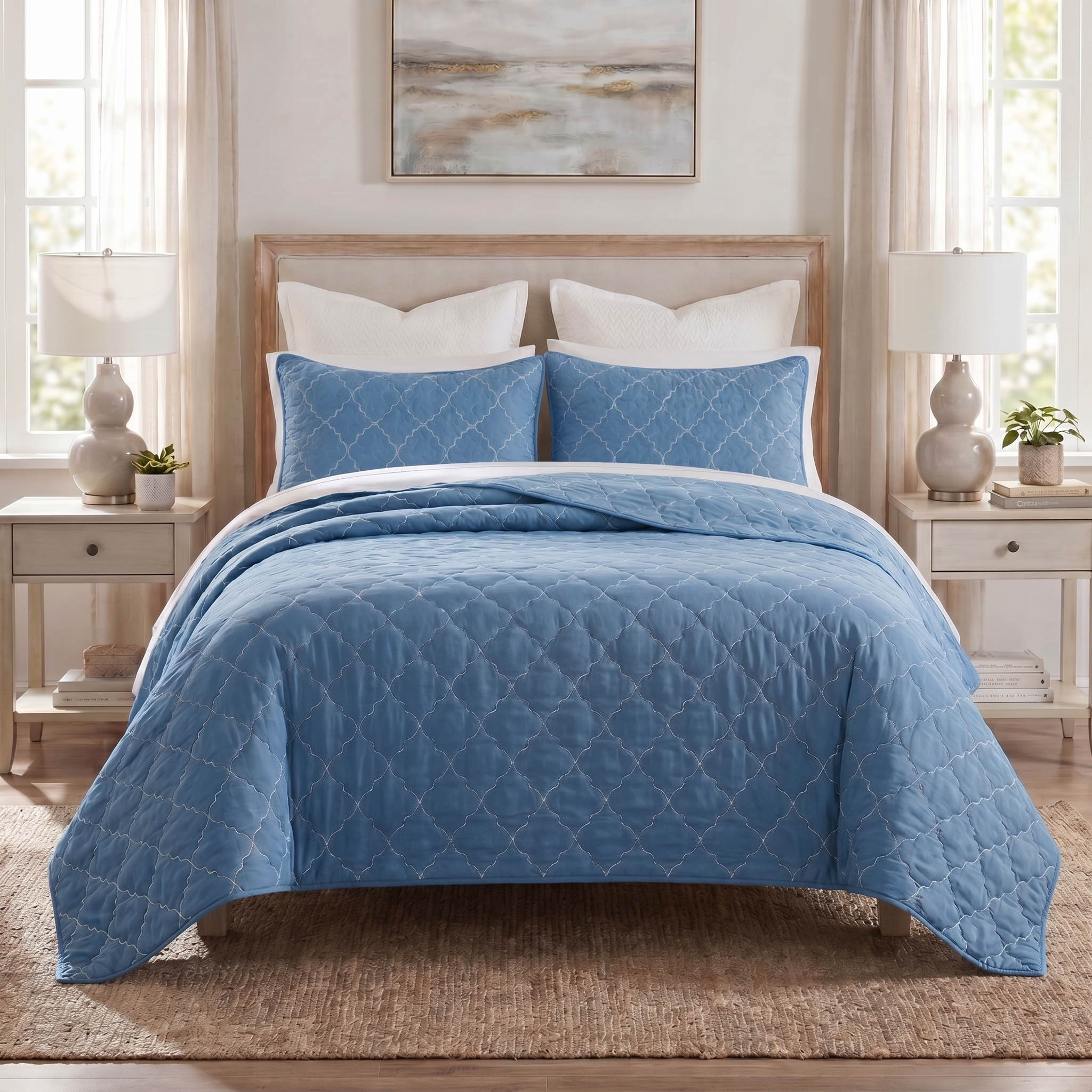 Blue quilted coverlet on a bed in a bedroom setting with lamps and decor.